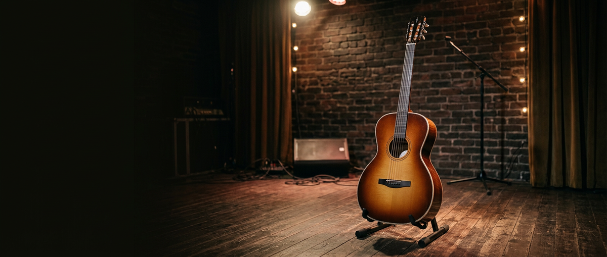 Eine Alvarez Laureate LT70 seht auf einem Gitarrenständer auf einer beleuchteten Bühne
